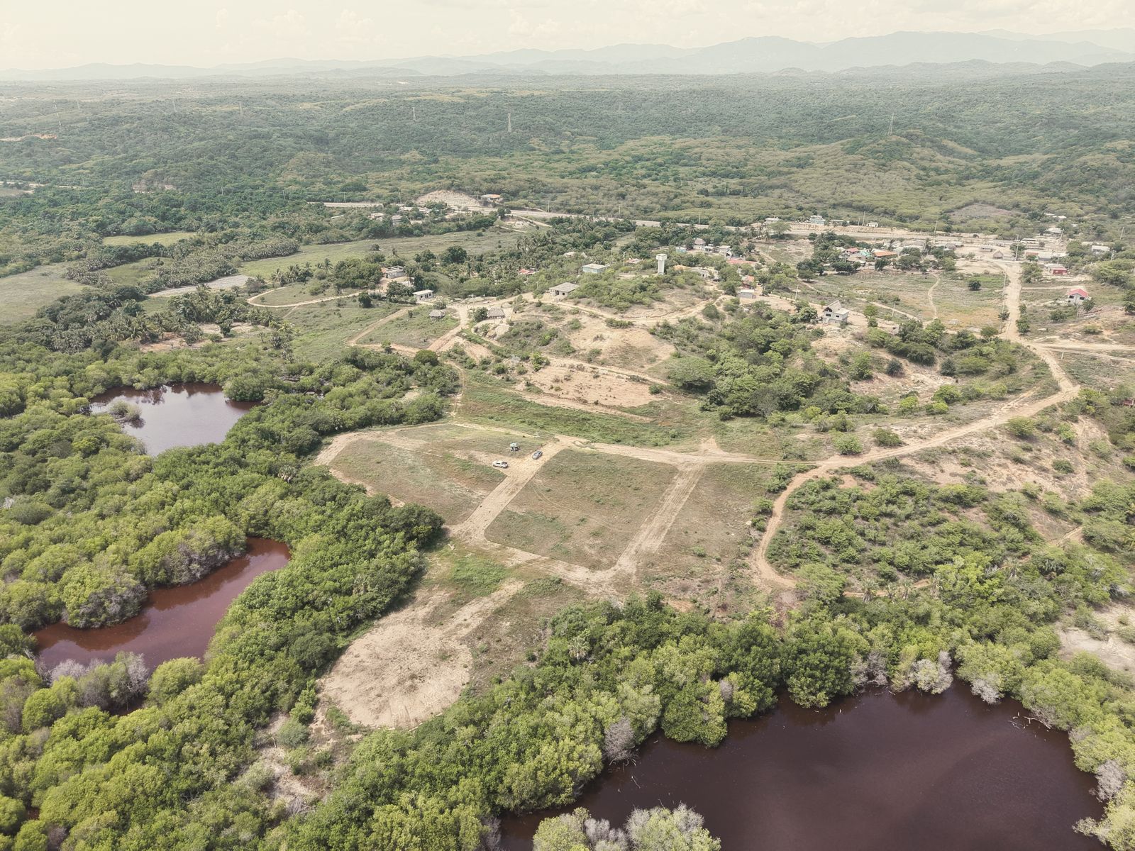 Fotografía aérea del terreno con sus calles trazadas, entre las lagunas y el pueblo de Vainilla